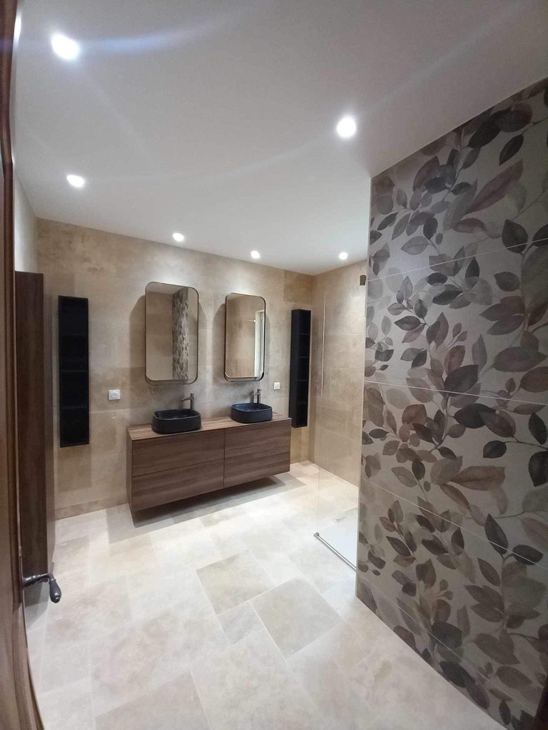 Vue générale d'une salle de bain contemporaine avec meuble vasque en bois et parement en pierre