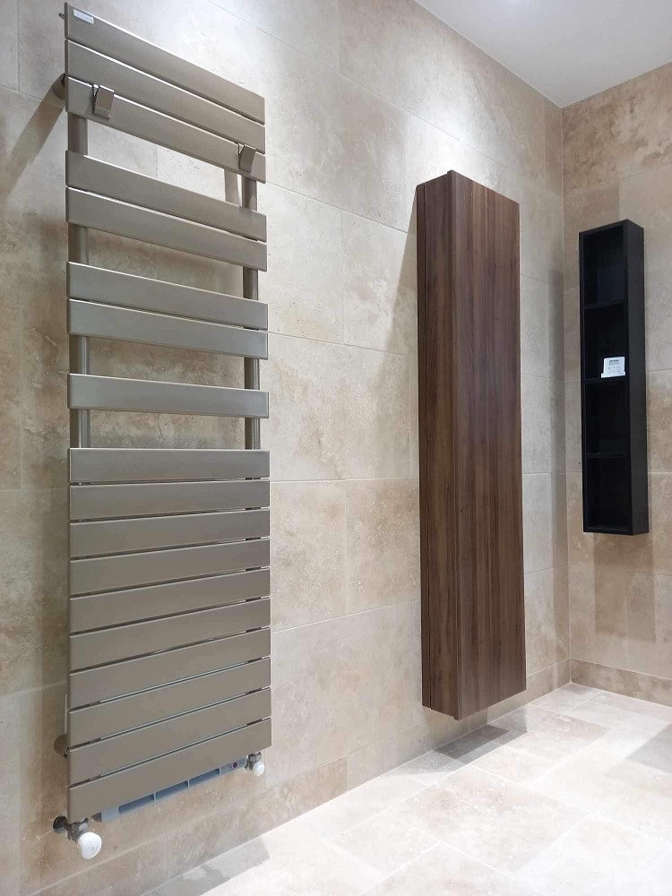 Sèche-serviettes et meuble colonne installés dans une salle de bain rénovée