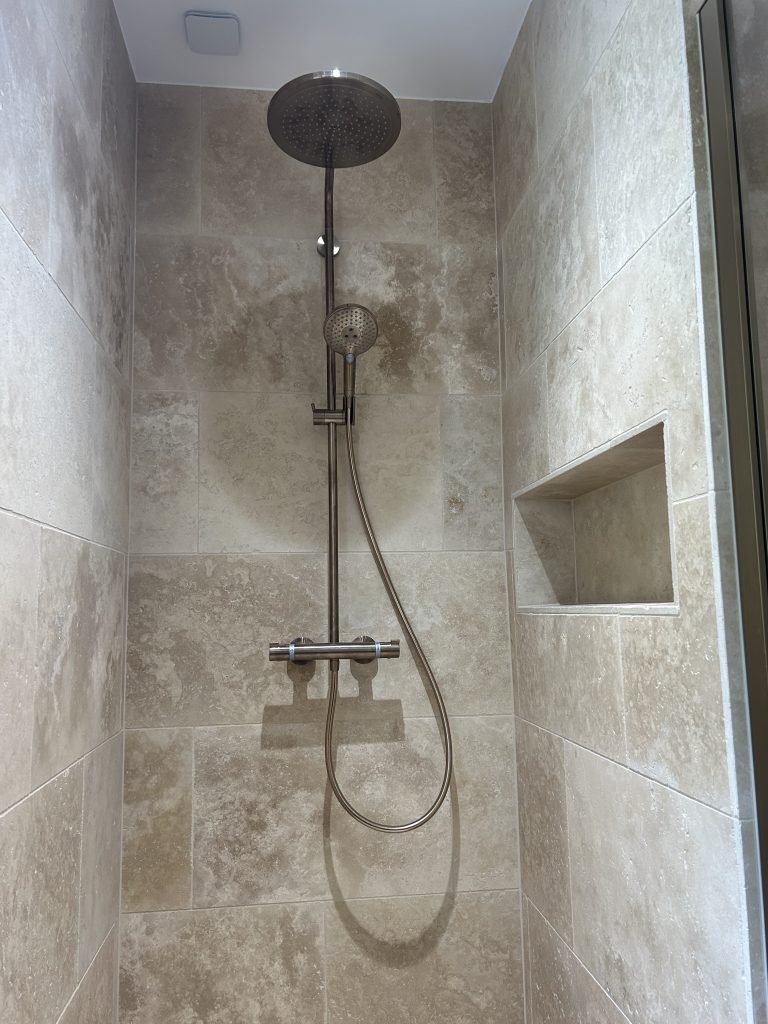 Douche à l'italienne en travertin avec niche de rangement intégrée