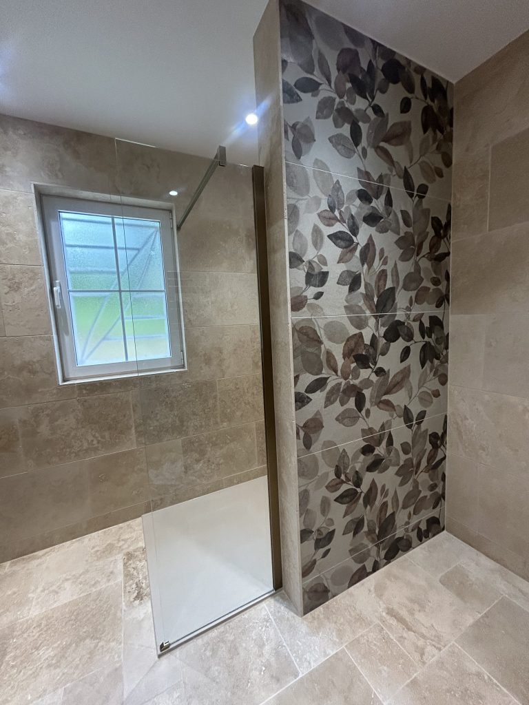 Fenêtre et mur décoratif en travertin dans une salle de bain rénovée