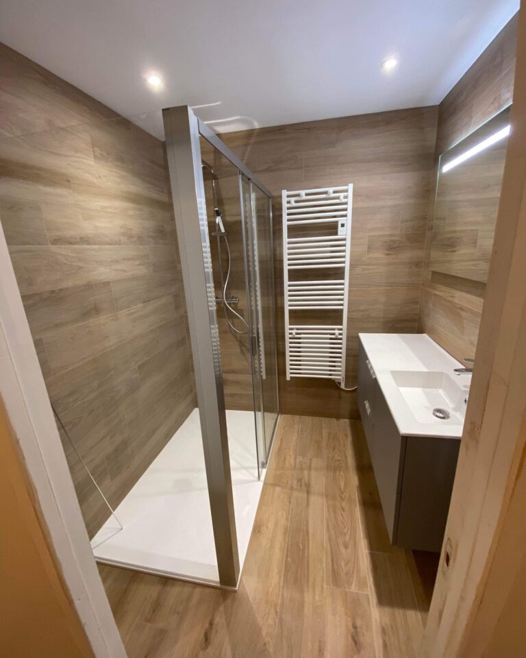 Salle de bain rénovée après un dégât des eaux avec douche à l'italienne et sèche-serviettes