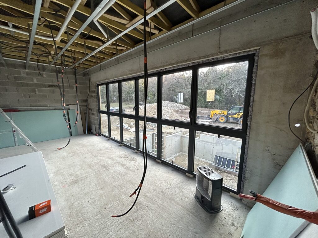 Grande pièce de vie en cours de rénovation dans une bâtisse en pierre