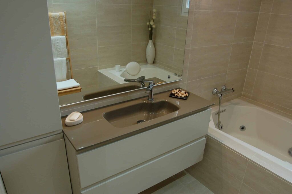 Meuble vasque suspendu installé à côté d’une baignoire balnéo.