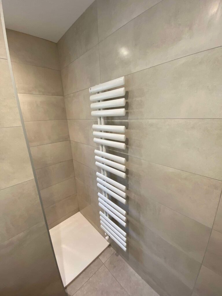 Sèche-serviettes blanc installé dans une salle de bain moderne à La Bégude-de-Mazenc
