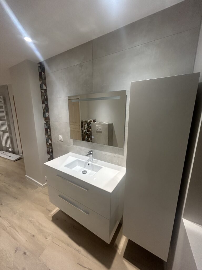 Meuble de salle de bain avec grand miroir après rénovation complète
