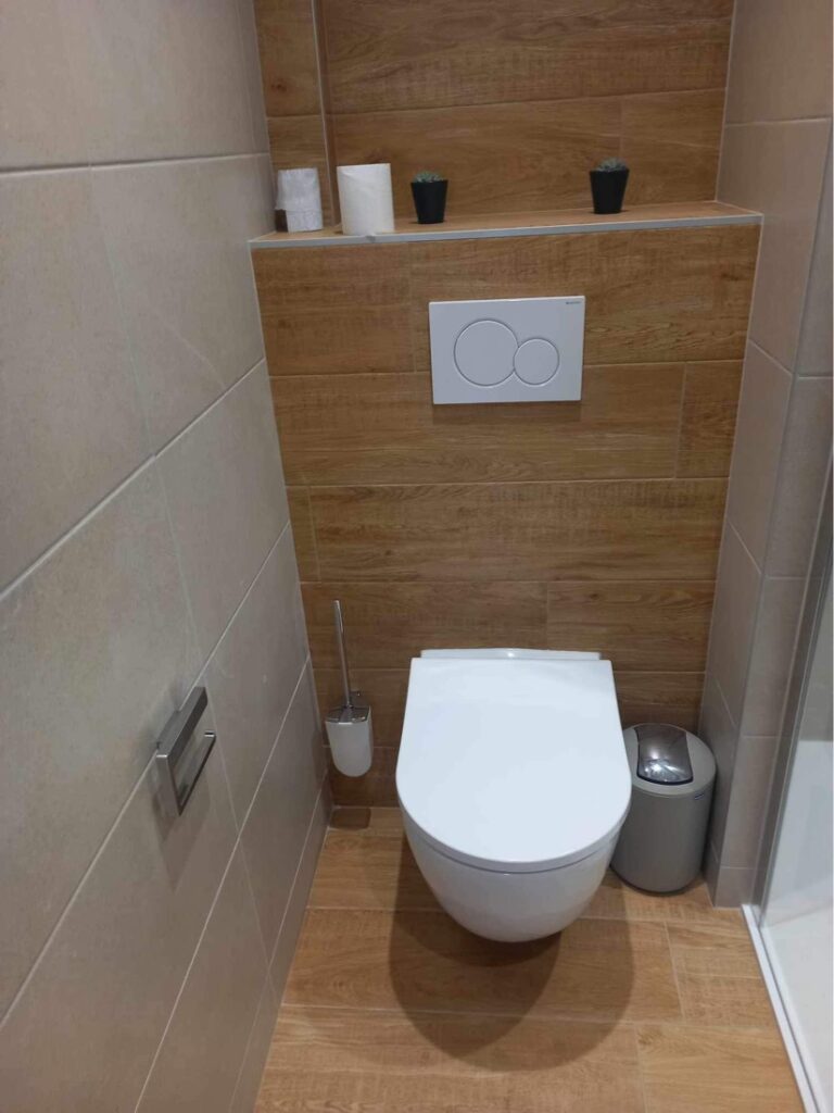 WC suspendu installé lors d'une rénovation de salle de bain avec habillage en carrelage imitation bois réalisé par Drôme Rénovation.