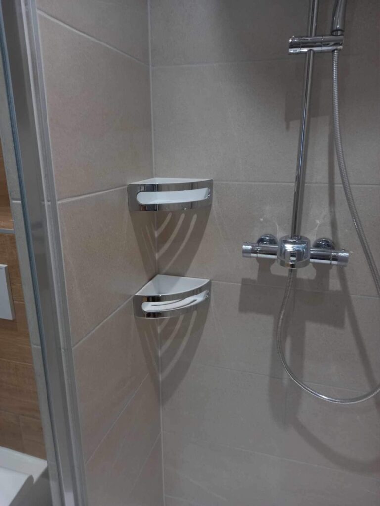 Étagères d'angle installées dans une douche à l'italienne