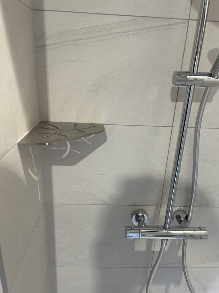 Tablette de douche thermostatique installée dans une salle de bain d'hôtel rénovée à Grignan.