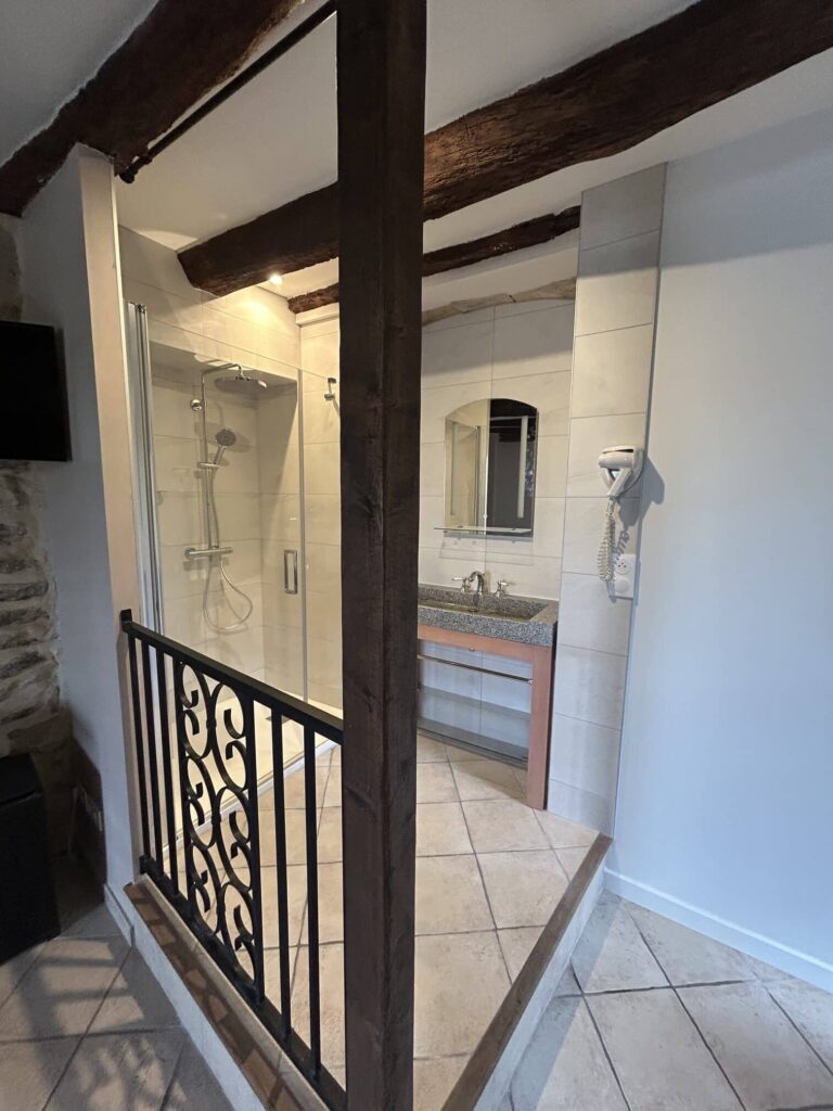 Entrée d'une salle de bain rénovée dans un hôtel à Grignan avec finitions modernes.