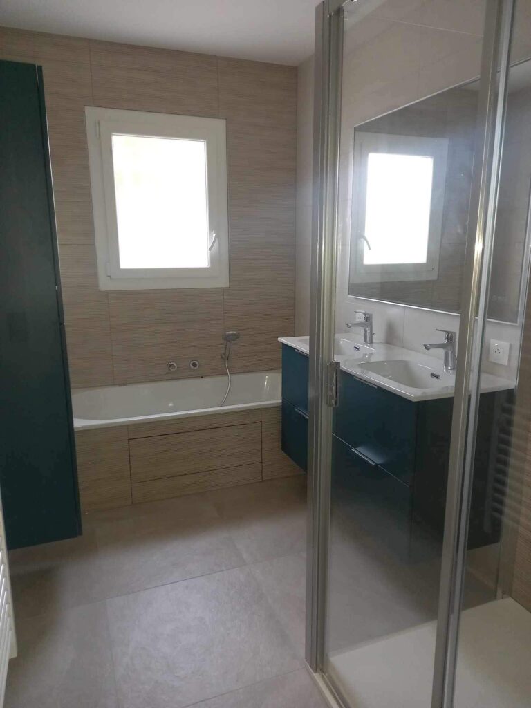 Salle de bain rénovée avec meuble vasque bleu et douche vitrée à Livron