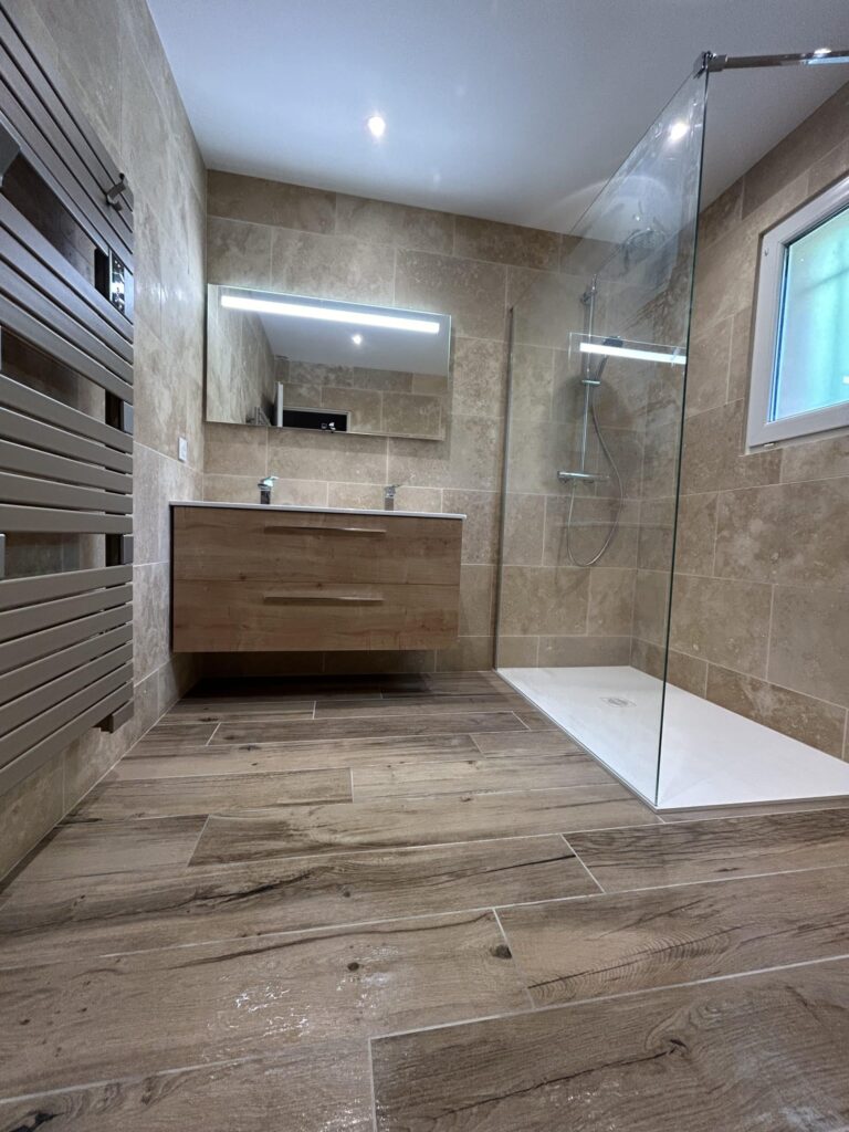Salle de bain rénovée à Puy-Saint-Martin avec douche à l'italienne, meuble double vasque suspendu et carrelage effet pierre