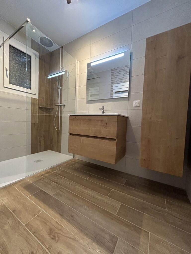 Vue d'ensemble d'une salle de bain rénovée avec douche à l'italienne et mobilier contemporain.