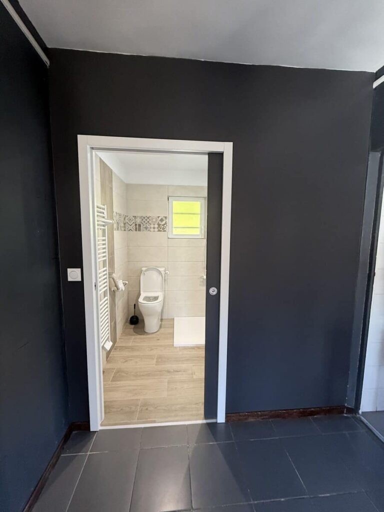 Accès à une salle de bain PMR avec douche à l'italienne