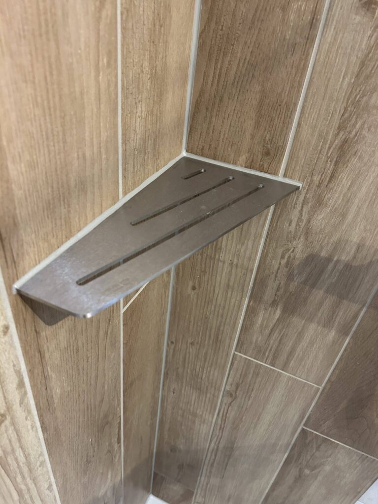 Tablette de douche murale en inox installée dans une salle de bain rénovée par Drôme Rénovation.