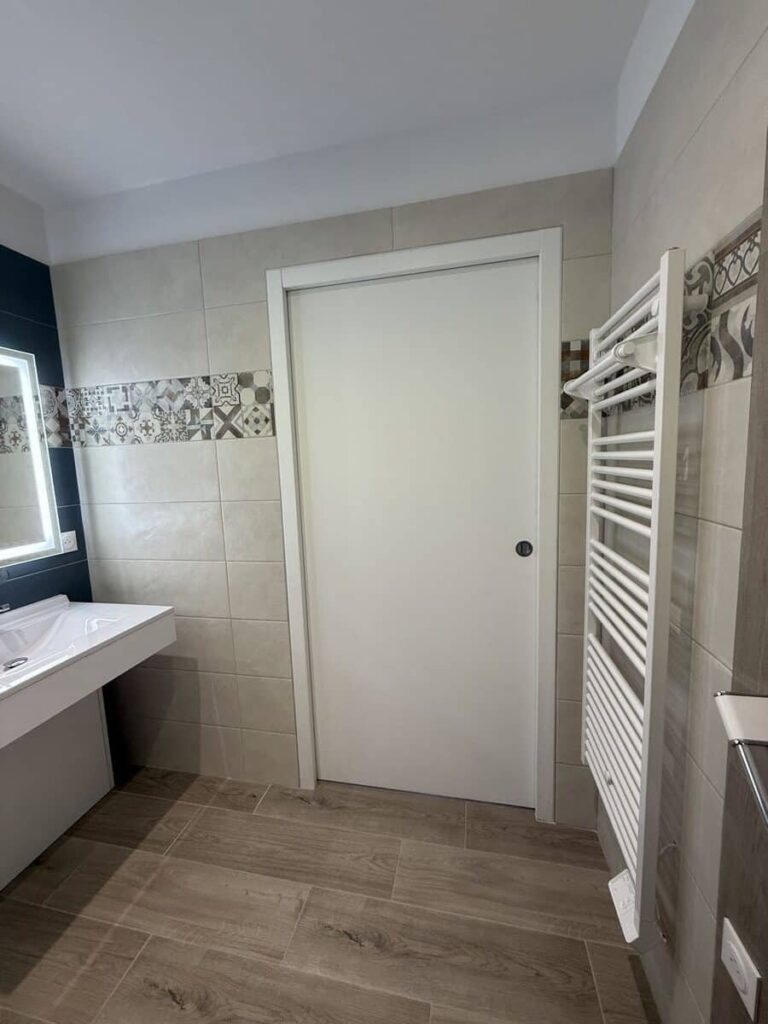 Salle de bain PMR avec sèche-serviettes et douche accessible