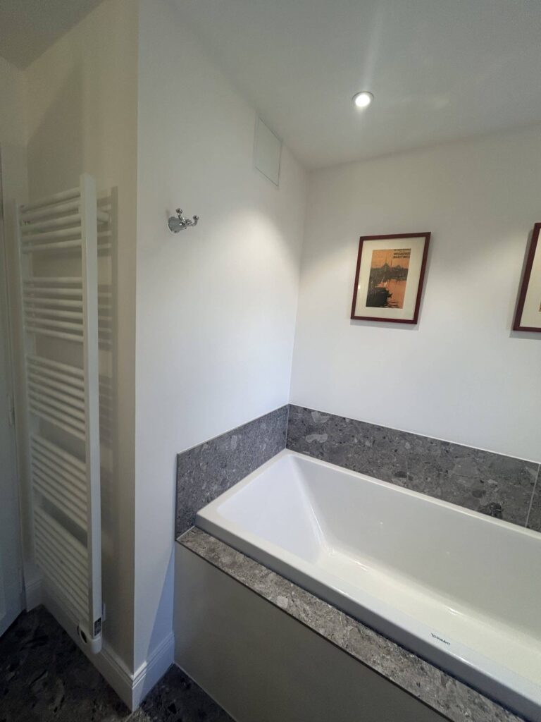 Baignoire intégrée avec sèche-serviettes dans une salle de bain rénovée à Salette.