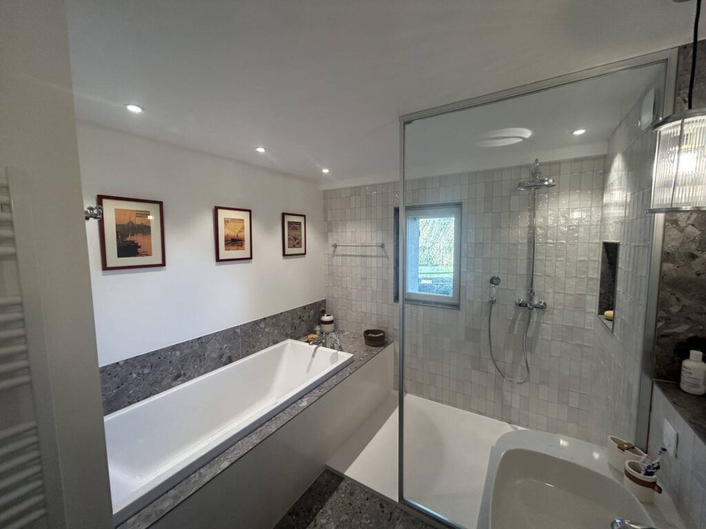 Salle de bain rénovée à Salette avec baignoire, douche à l'italienne et paroi vitrée.