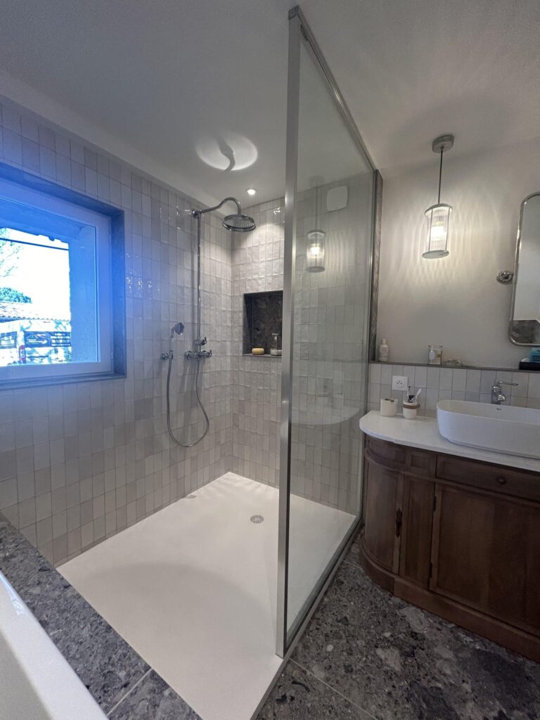 Grande douche à l'italienne réalisée lors d'une rénovation d'une salle de bain à Salette avec faïence effet zellige.