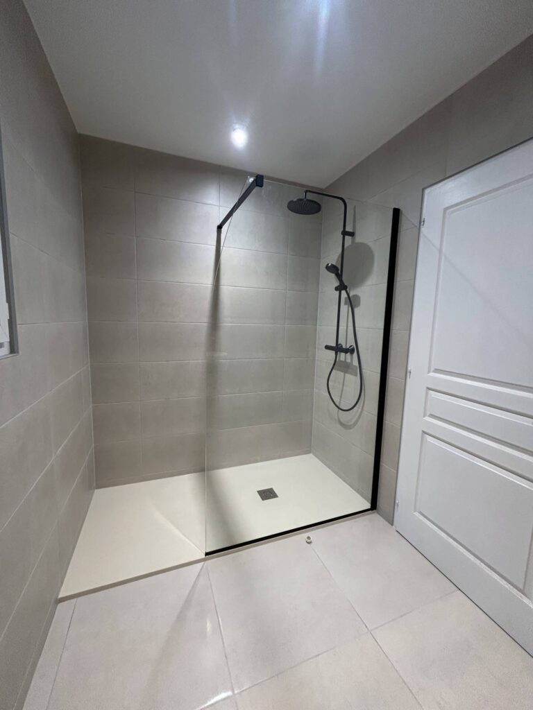 Vue générale de la douche à l'italienne avec paroi vitrée dans une salle de bain rénovée à Cléon-d'Andran.