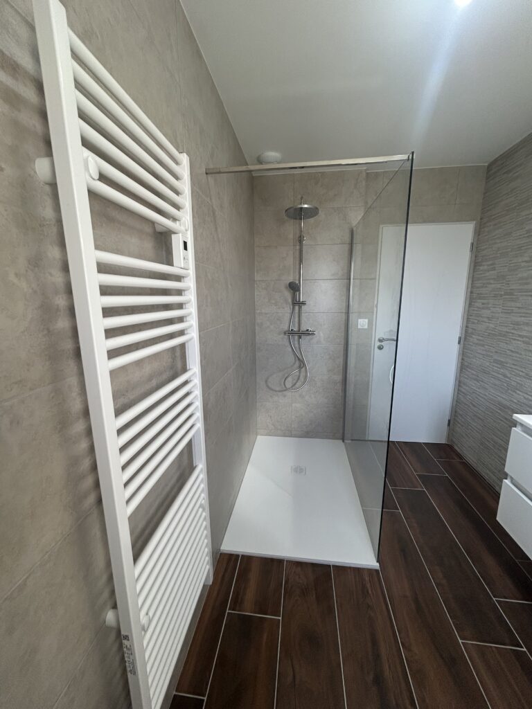 Salle de bain rénovée après un dégât des eaux avec douche à l'italienne et double vasque.