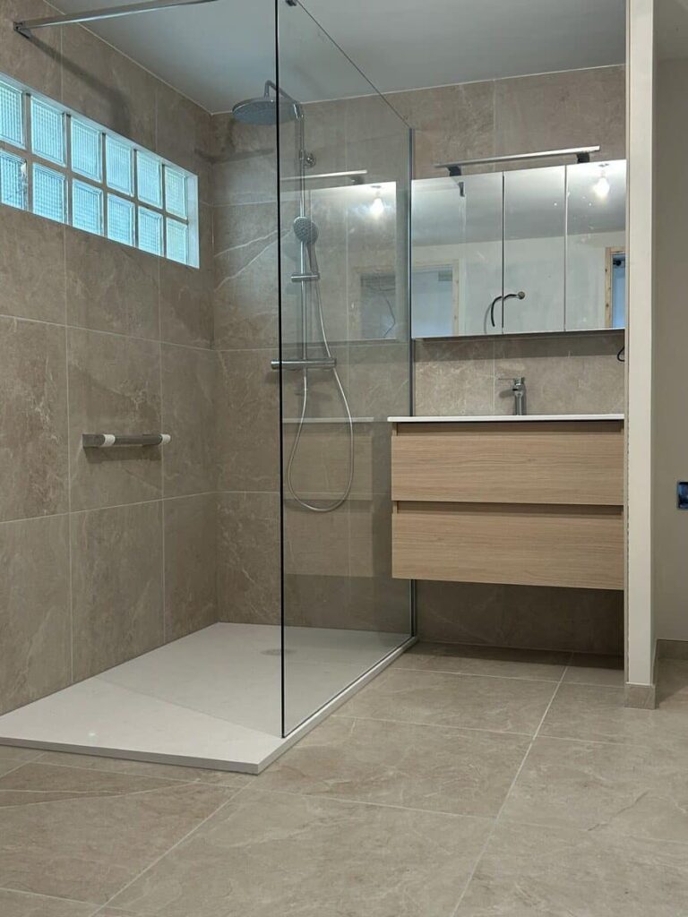 Salle de bain rénovée avec douche à l'italienne et meuble vasque en bois