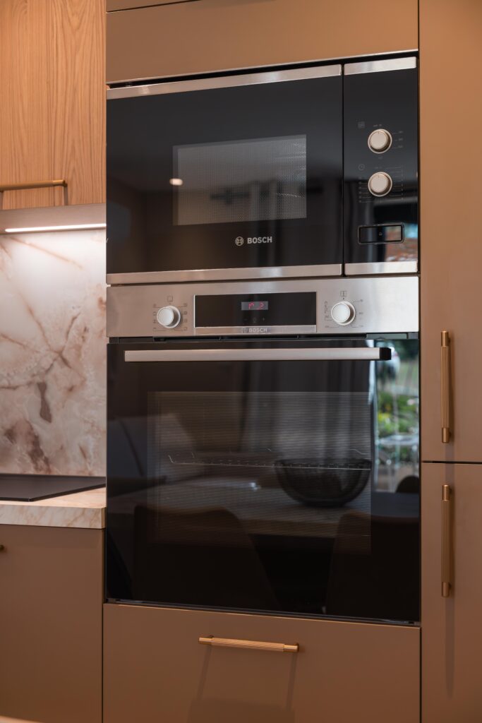 Électroménager encastré dans une cuisine taupe et bois