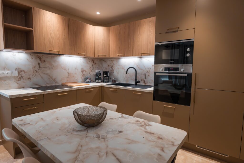 Cuisine taupe et bois avec espace repas et finitions effet marbre